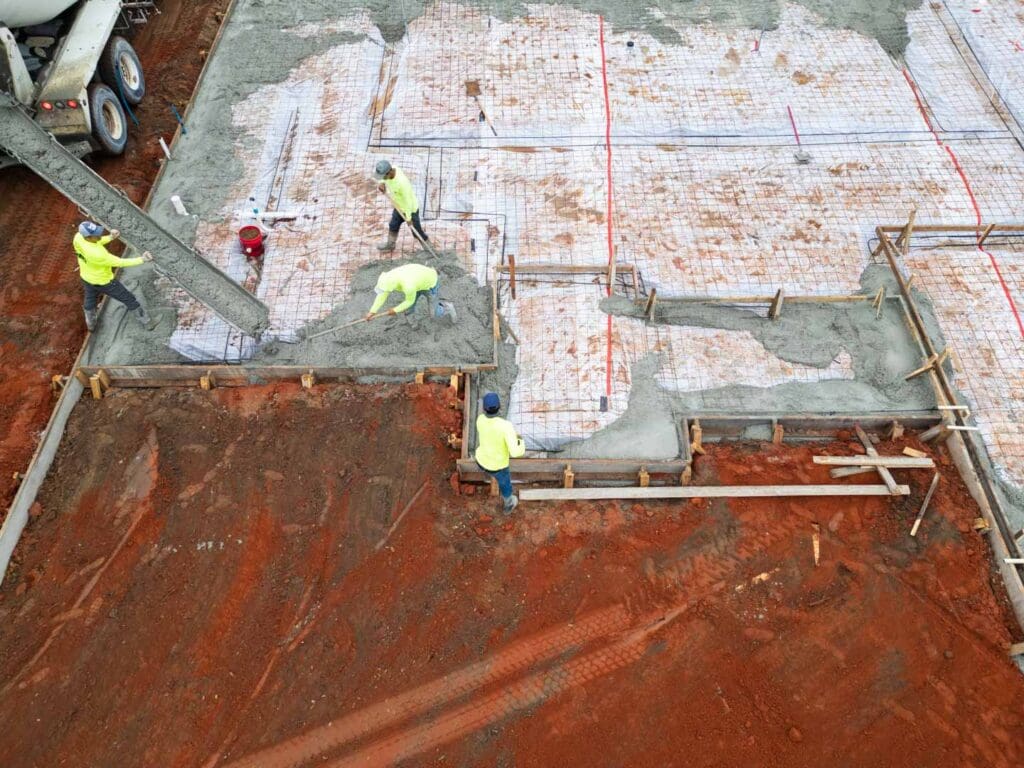 a team of builders from live oak custom homes pouring the foundation